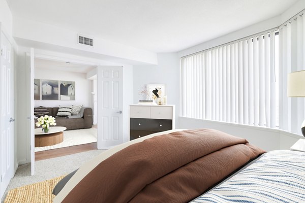 Cozy bedroom with stylish decor and large windows at Marlowe Apartments