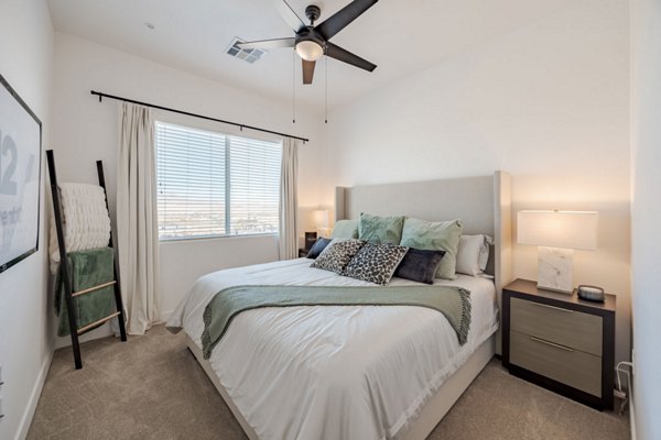 Cozy bedroom featuring modern decor and ample natural light at Element 12 at Cadence Apartments