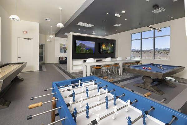 Clubhouse game room with pool table and lounge seating at Element 12 at Cadence Apartments