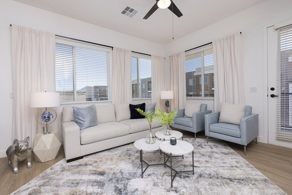 Modern living room with cozy seating and artistic decor at Element 12 at Cadence Apartments, a luxury property by Greystar