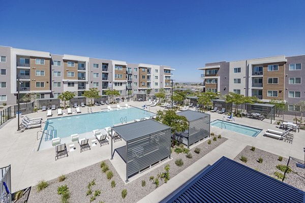 Rooftop pool with lounge chairs at Element 12 at Cadence Apartments, offering luxury relaxation in a vibrant community setting