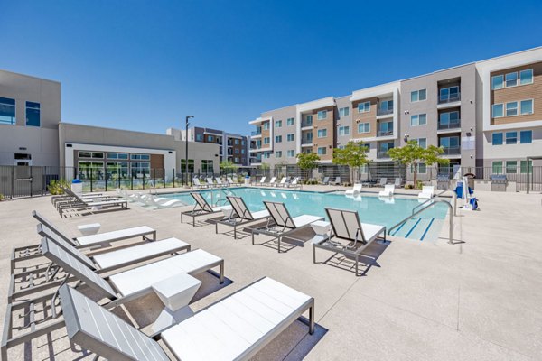 Rooftop pool with lounge chairs at Element 12 at Cadence Apartments, offering luxury amenities for relaxation and recreation