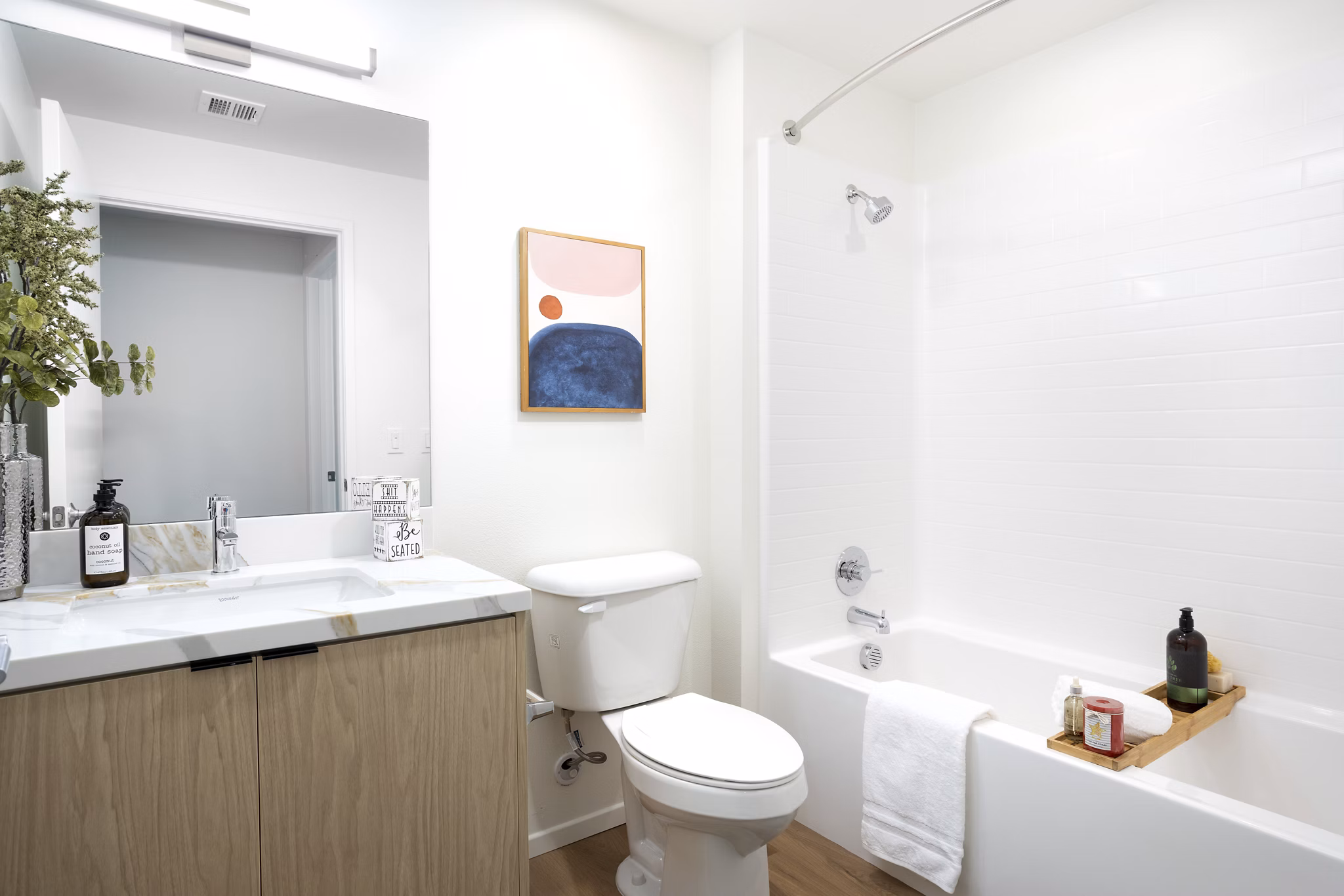 Modern bathroom featuring a sink, toilet, bathtub, and shower in luxury apartments