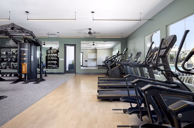 Fitness center with treadmills, exercise machines, and weights at luxury apartments