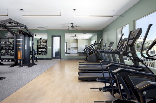 Fitness center with treadmills, exercise machines, and weights at luxury apartments
