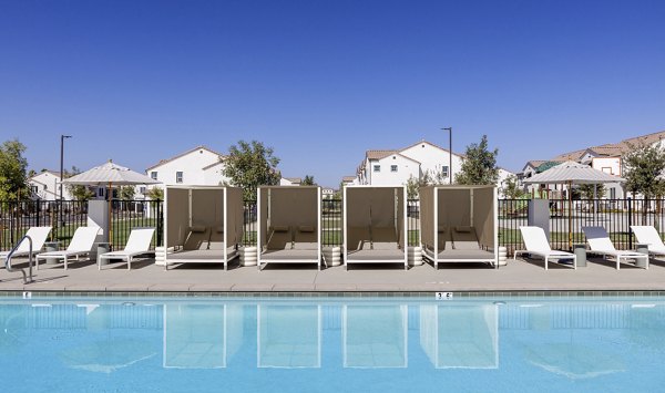 Luxurious swimming pool with lounge chairs and cabanas at Greystar luxury apartments