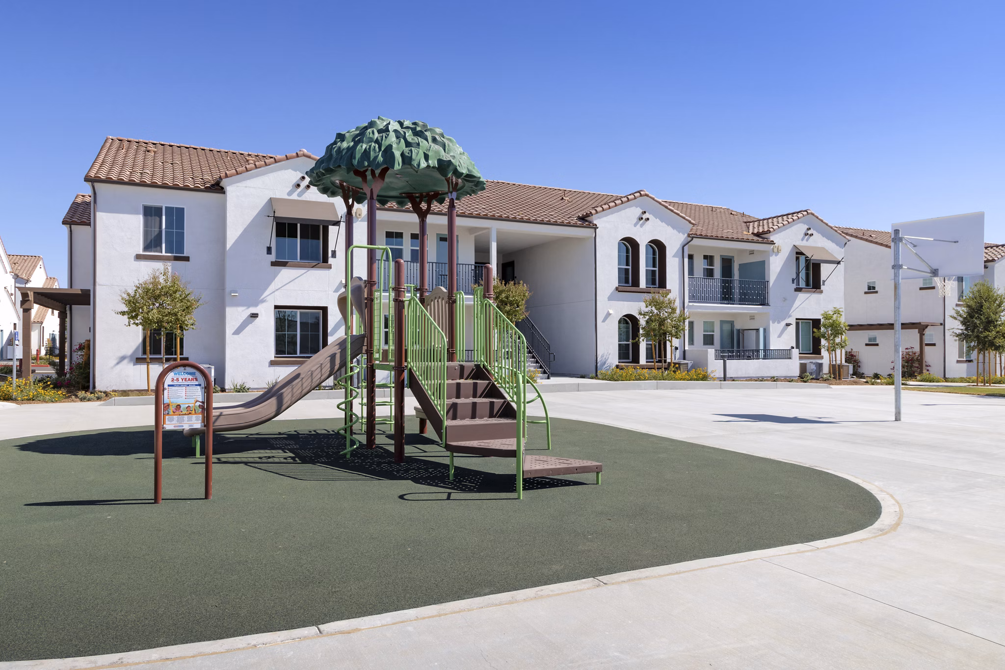 Playground with a slide and climbing structure at luxury apartments in a scenic outdoor area