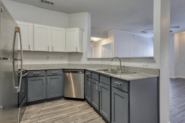 Modern kitchen with sleek countertops and stainless steel appliances at The Jax Apartments