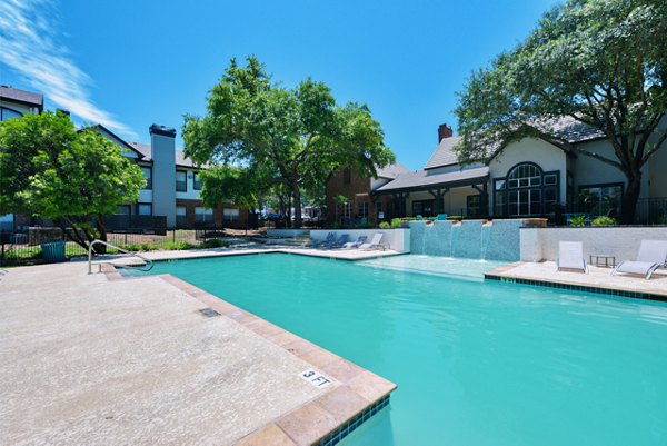 Luxurious pool with sun loungers at The Jax Apartments, perfect for relaxation in a serene setting