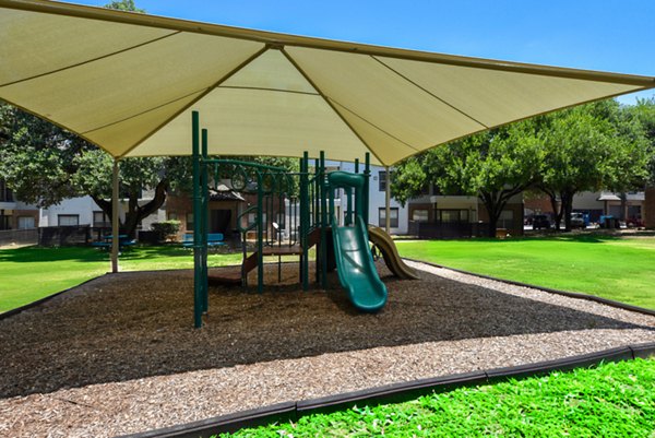 Playground with modern play equipment at The Jax Apartments, ideal for family-friendly living