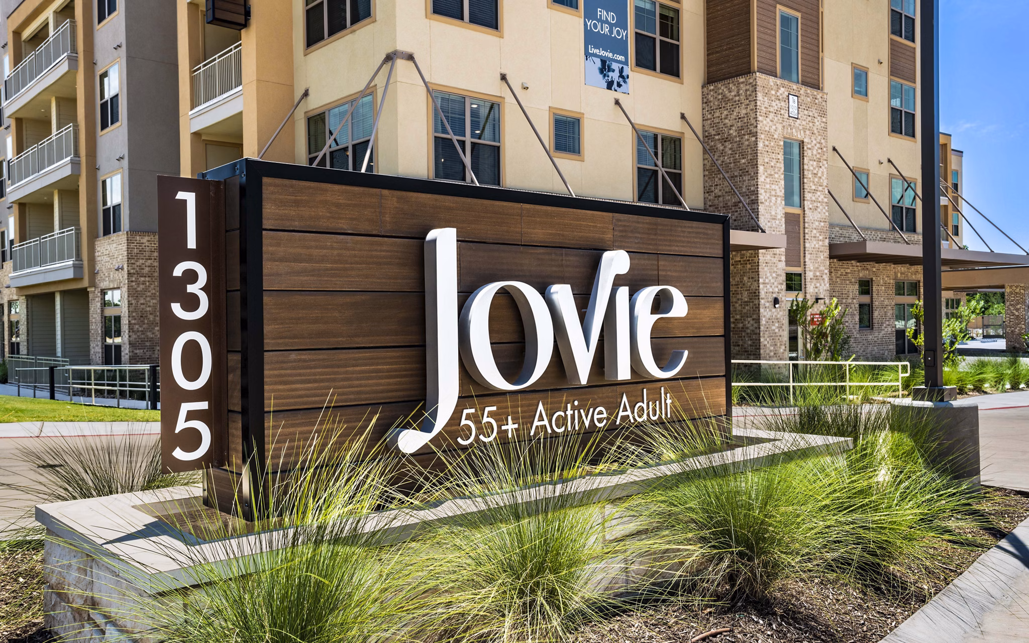 Signage at Jovie Pflugerville Apartments displaying the property's name and branding elements in a modern font style