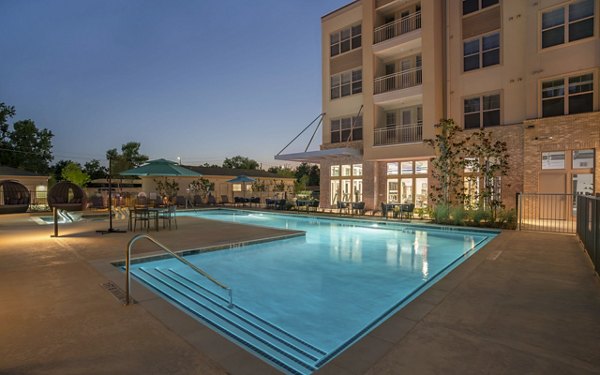 Modern pool with sun loungers at Jovie Pflugerville Apartments offering luxury outdoor relaxation