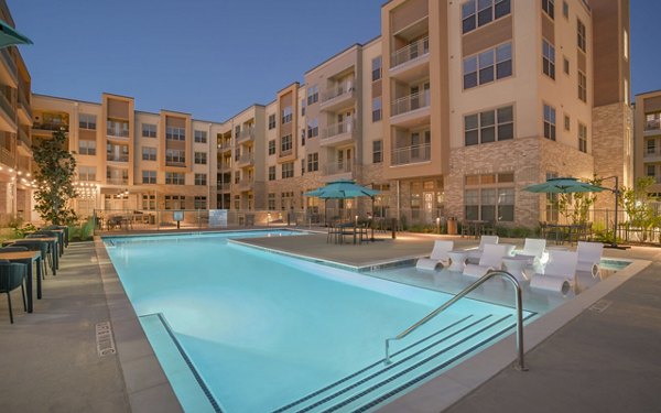 Resort-style pool with loungers at Jovie Pflugerville Apartments