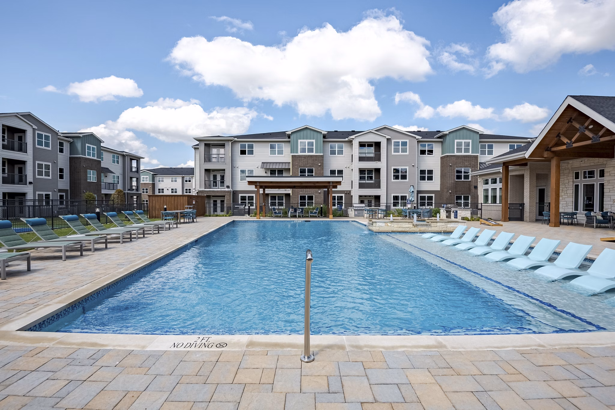 Sparkling pool with lounge chairs at Prose Greenbriar Apartments