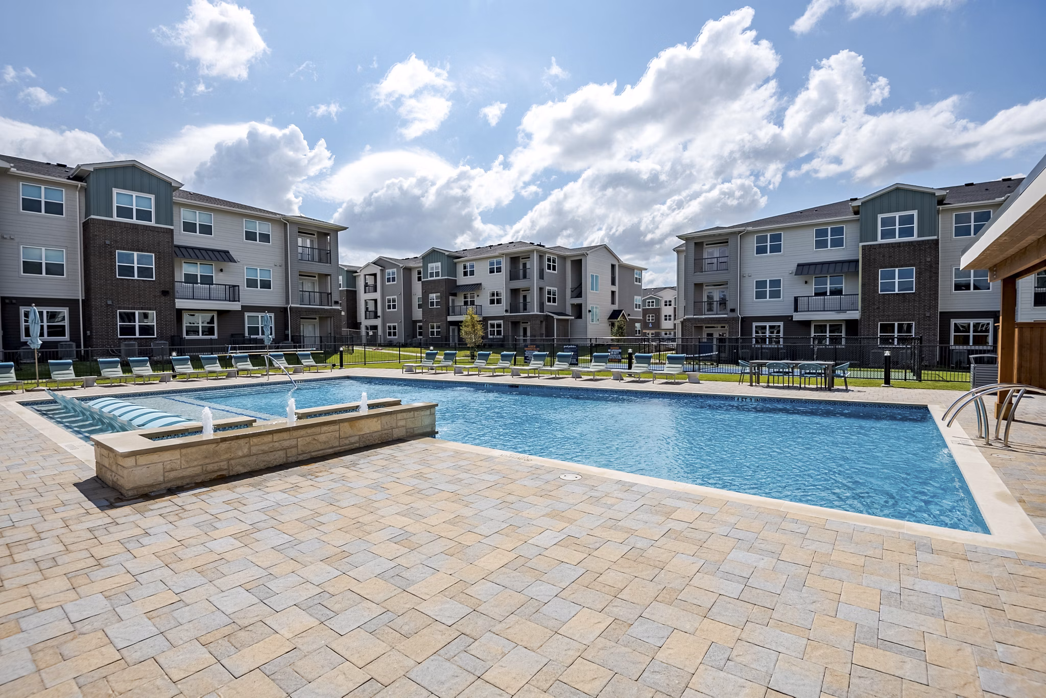 Resort-style swimming pool at Prose Greenbriar Apartments with sun loungers and palm trees enhancing the luxury living experience