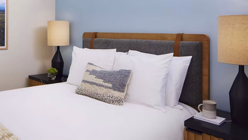 Cozy bedroom featuring modern decor and large windows in CHROMA Apartments