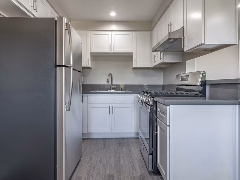 Modern kitchen with granite countertops and stainless steel appliances in Citrus Court Apartments