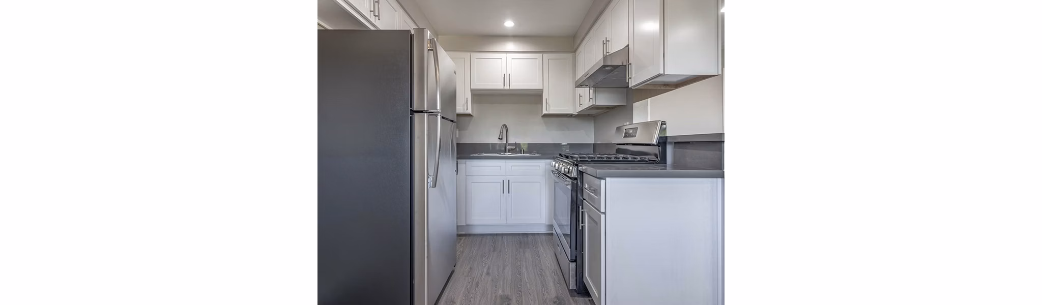 Modern kitchen with granite countertops and stainless steel appliances in Citrus Court Apartments