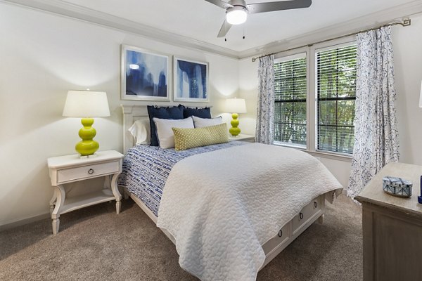 Elegant bedroom with modern decor at Gramercy at Buckhead Apartments, featuring plush bedding and ample natural light