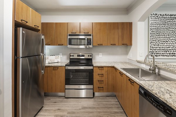 Modern kitchen featuring stainless steel appliances and granite countertops in Gramercy at Buckhead Apartments