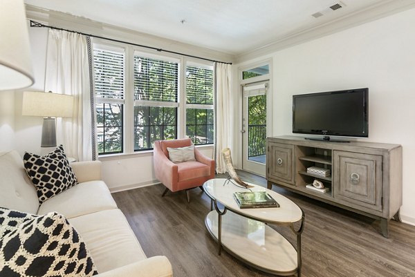 Cozy living room with stylish decor and large windows at Gramercy at Buckhead Apartments