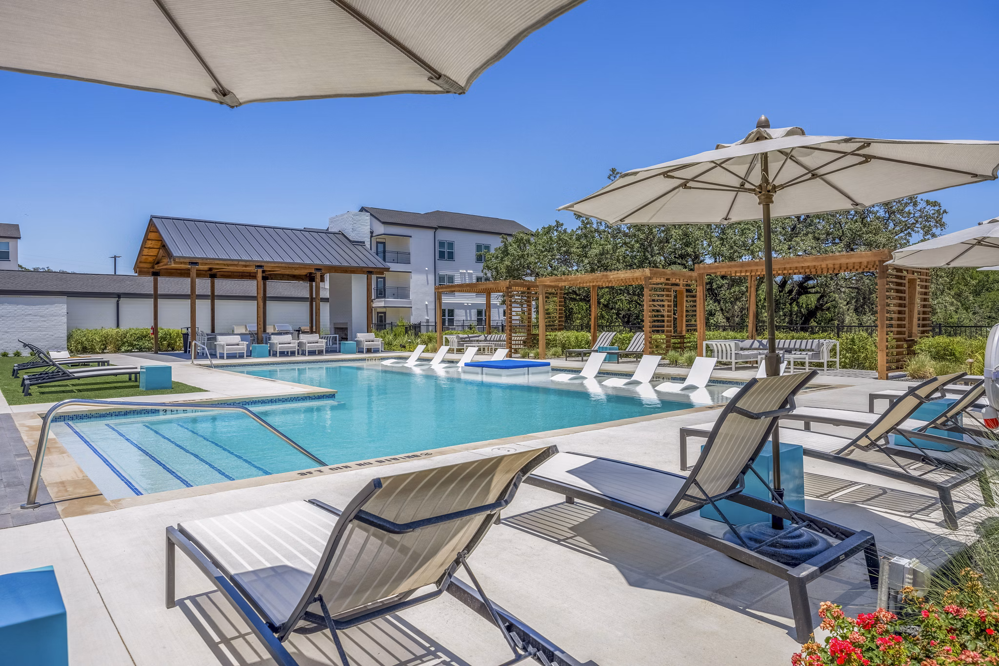 Napa Oaks Apartments pool with sun loungers and landscaped greenery, offering luxury apartments with resort-style amenities