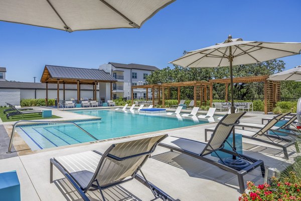 Napa Oaks Apartments pool with sun loungers and landscaped greenery, offering luxury apartments with resort-style amenities
