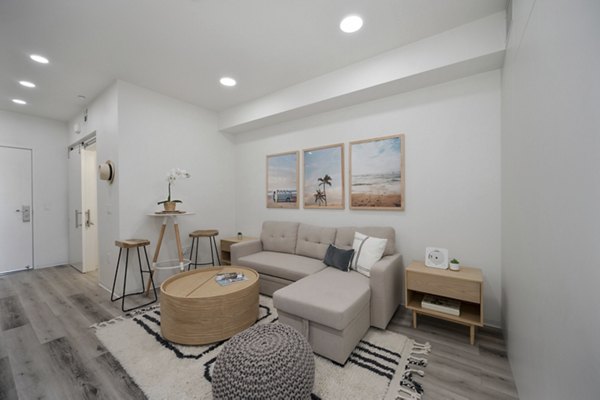 Modern living room with cozy seating in 3167 Market Apartments, featuring stylish decor and ample natural light