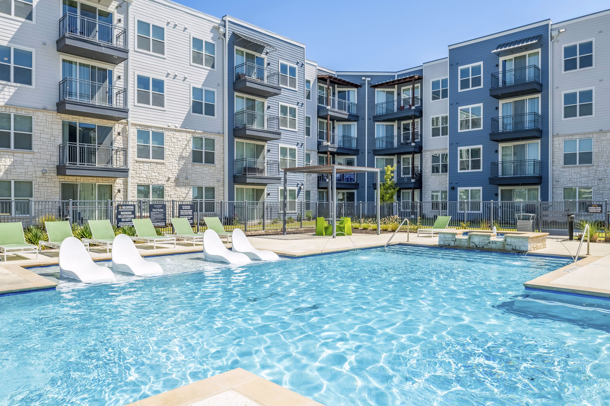 Inviting pool surrounded by lounge chairs at The District in Little Elm Apartments, perfect for relaxation and recreation