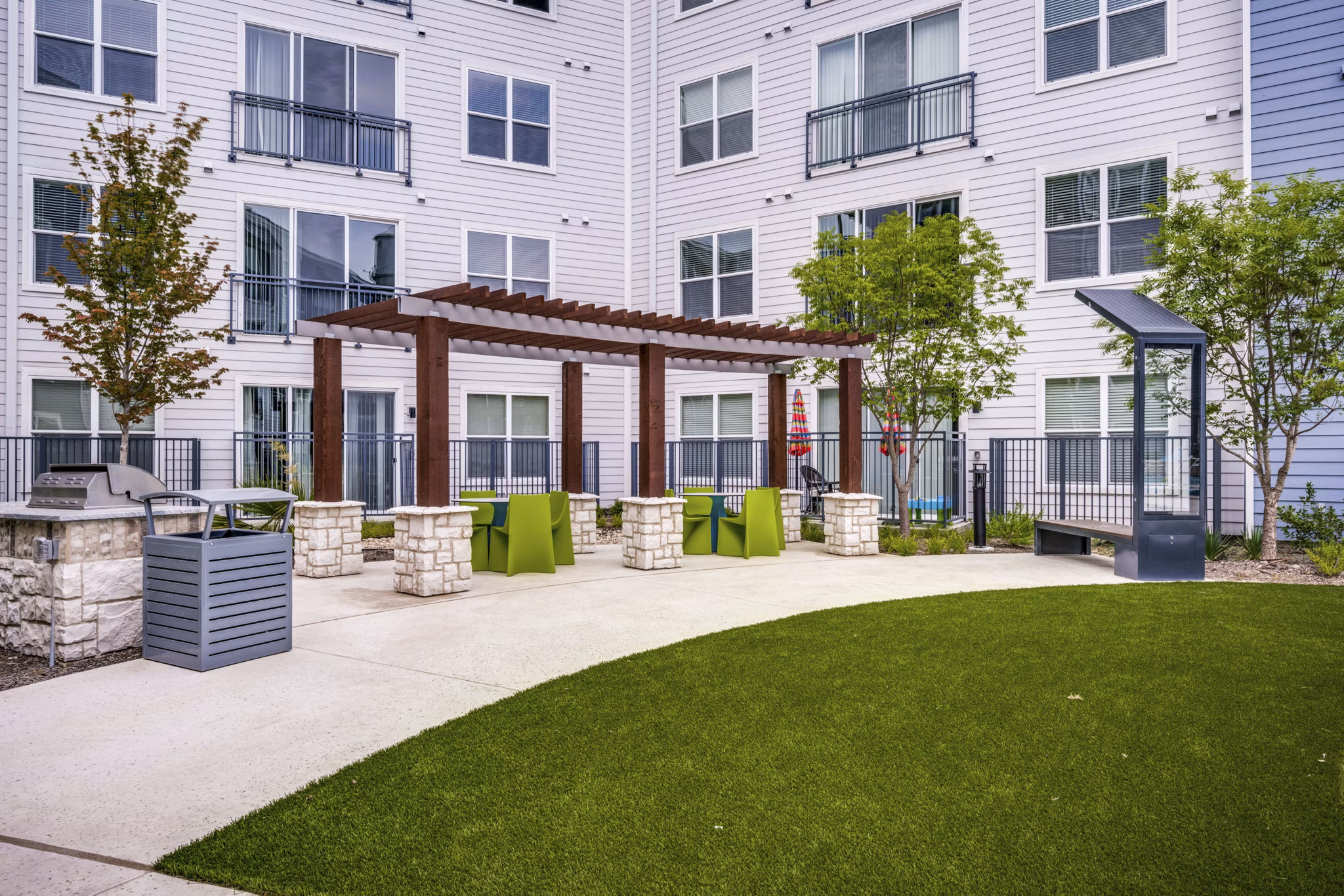 Courtyard with lush greenery and seating at The District luxury apartments in Little Elm