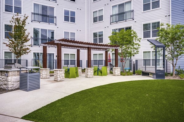 Courtyard with lush greenery and seating at The District luxury apartments in Little Elm