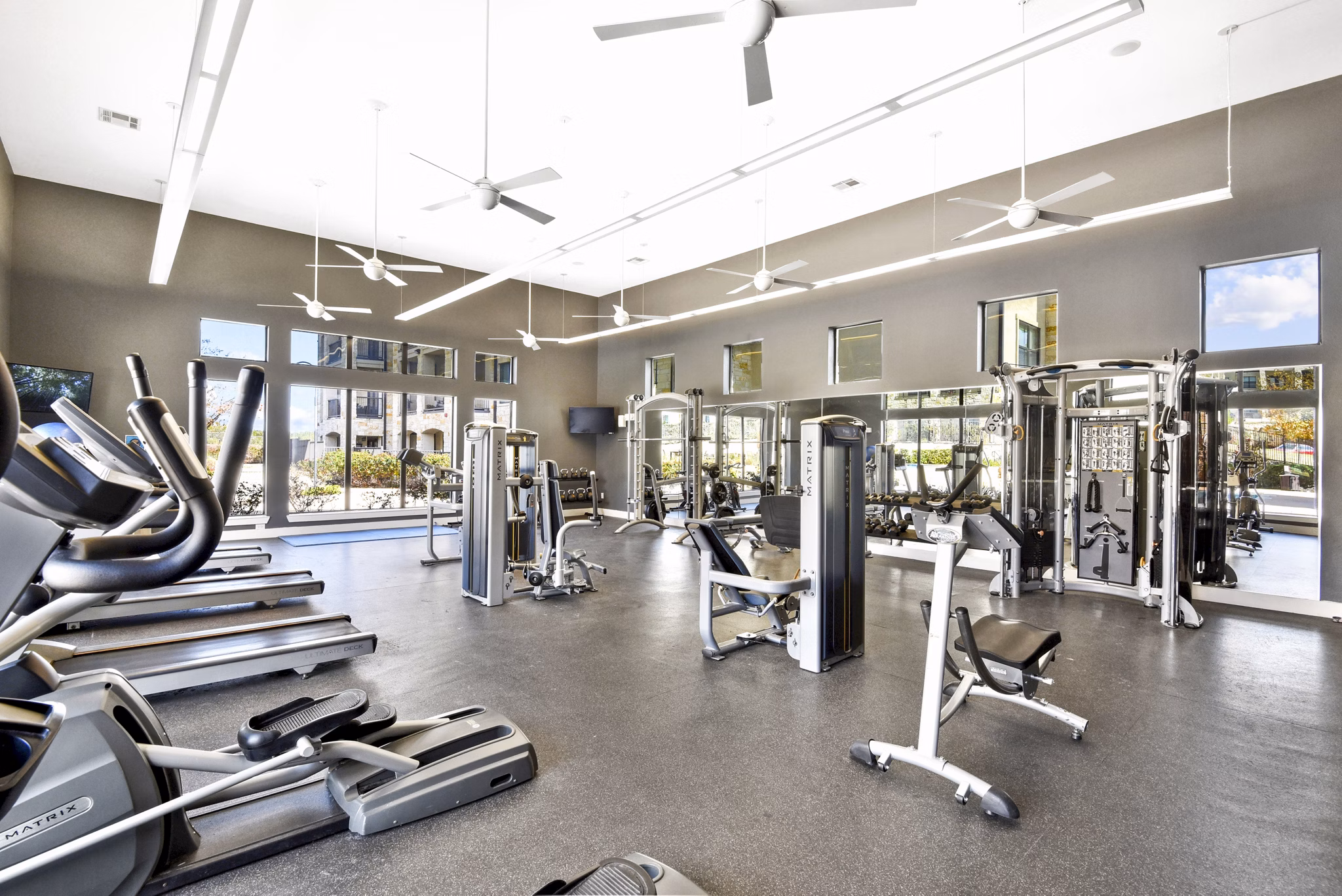 Fitness center with modern equipment at Agora Stone Oak Apartments, offering a luxury workout experience