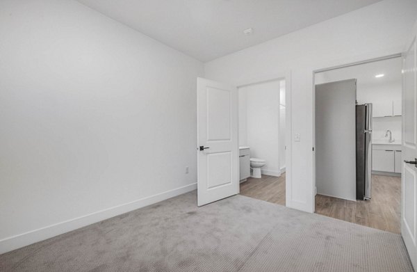 Bedroom featuring cozy decor and large windows at The Opal Apartments