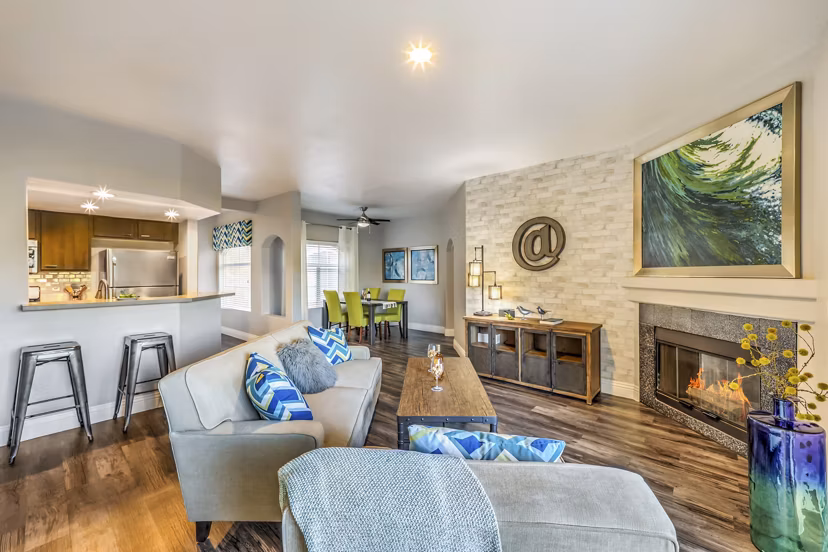 Living room with modern furnishings and large windows at Parkway Townhomes Apartments