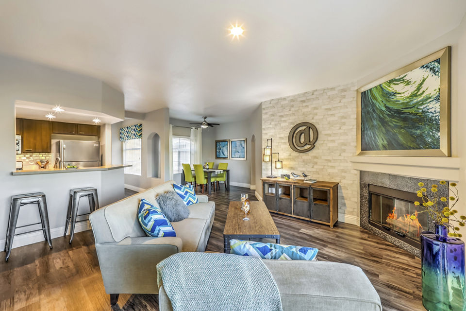 Living room with modern furnishings and large windows at Parkway Townhomes Apartments