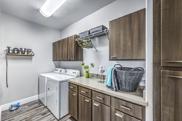 Laundry room featuring modern appliances at Parkway Townhomes Apartments