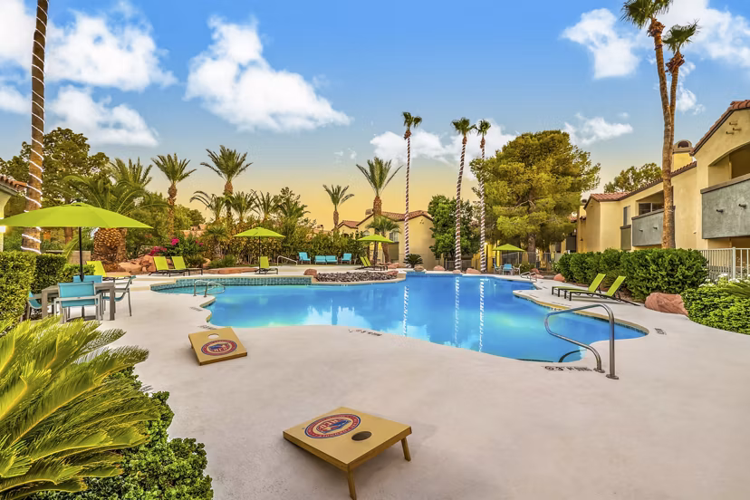 Resort-style pool at Parkway Townhomes with spacious lounge seats and lush landscaping, perfect for relaxation and enjoyment