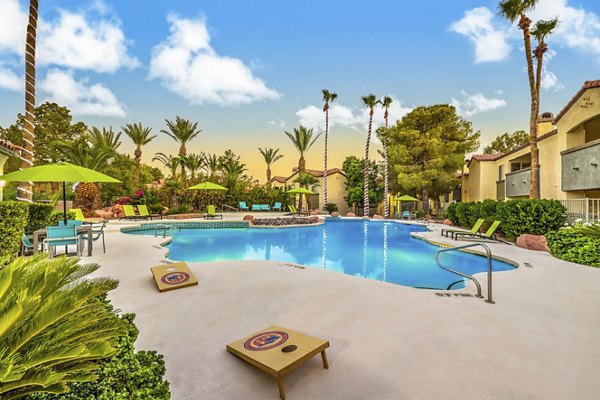 Resort-style pool at Parkway Townhomes with spacious lounge seats and lush landscaping, perfect for relaxation and enjoyment