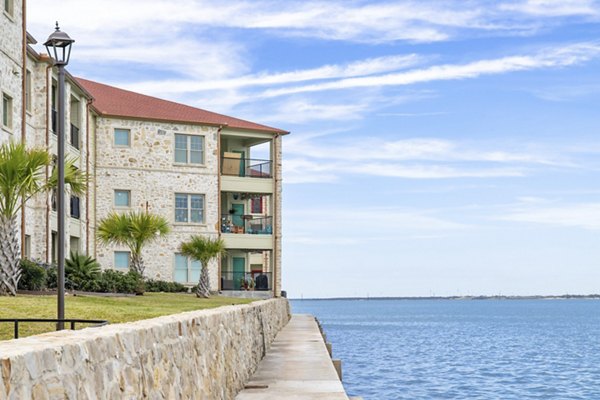 Resort-style swimming pool at Lighthouse Pointe Apartments with palm trees and lounge chairs