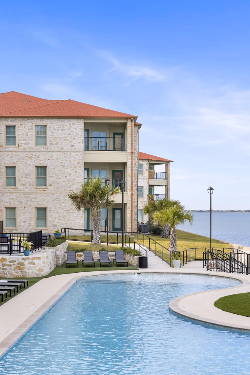 Resort-style pool with sun loungers at Lighthouse Pointe Apartments offering luxury living experiences near the waterfront