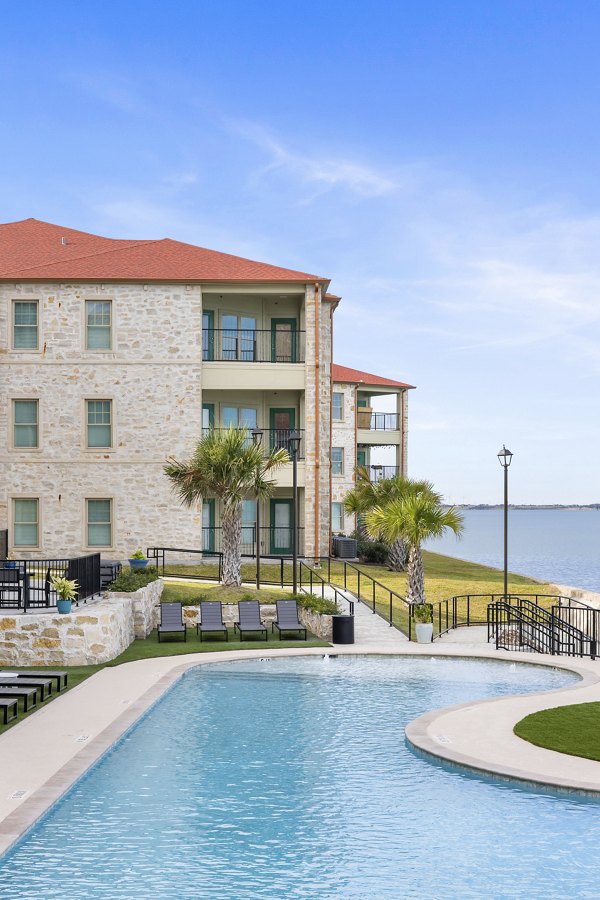 Resort-style pool with sun loungers at Lighthouse Pointe Apartments offering luxury living experiences near the waterfront