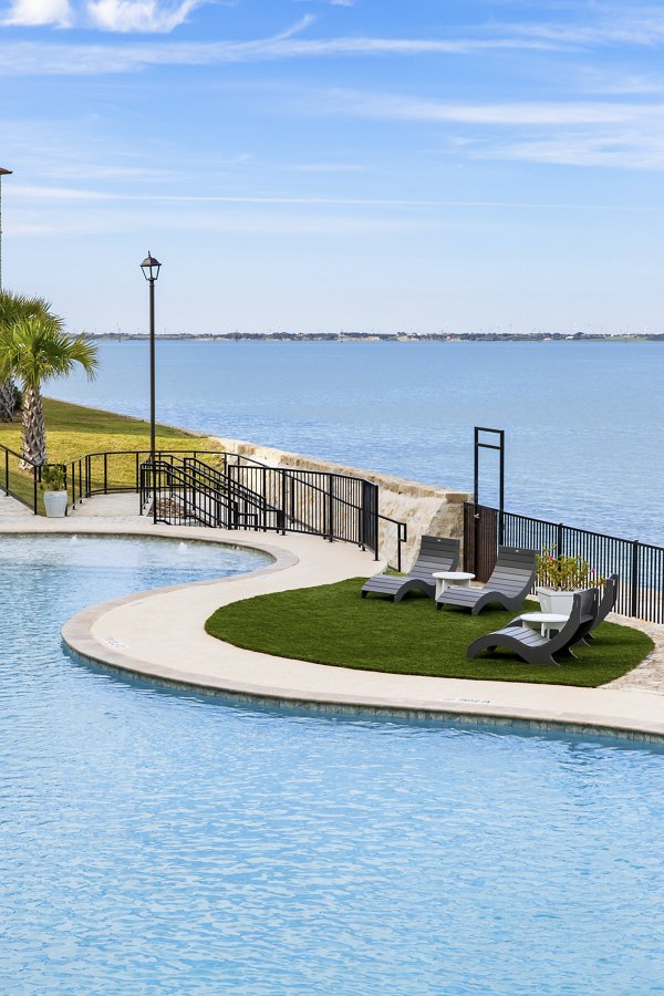 Relaxing pool area with palm trees at Lighthouse Pointe Apartments, offering luxurious water views and modern outdoor amenities