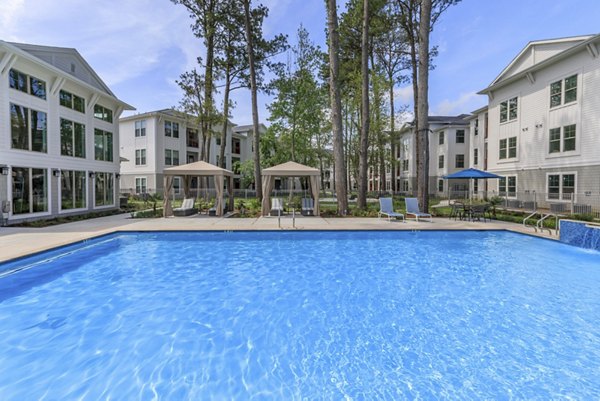 Outdoor pool with stylish loungers at Wyldewood Gosling Apartments, a luxury living community