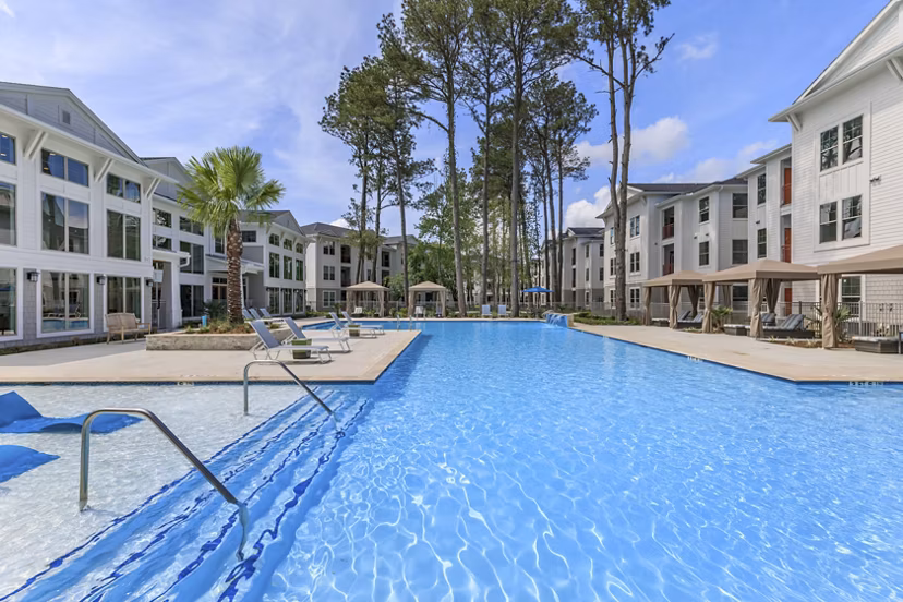 Resort-style pool area with lush landscaping at Wyldewood Gosling Apartments