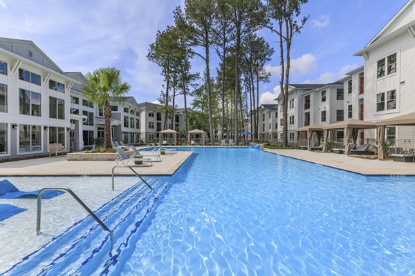 Resort-style pool area with lush landscaping at Wyldewood Gosling Apartments