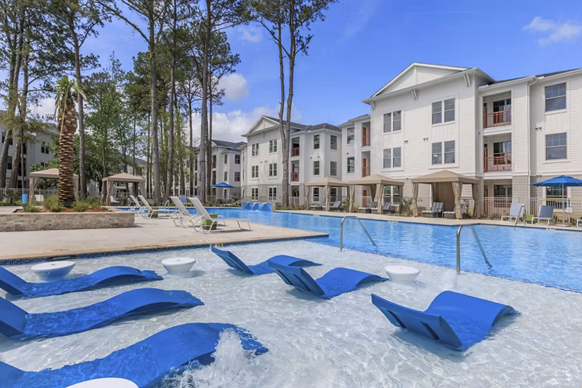Serene outdoor pool at Wyldewood Gosling Apartments with surrounding lush greenery
