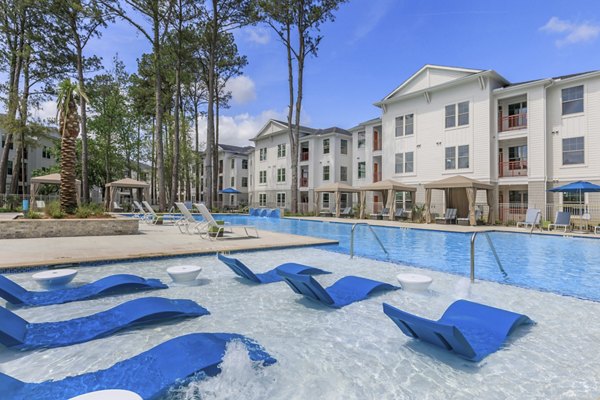 Serene outdoor pool at Wyldewood Gosling Apartments with surrounding lush greenery