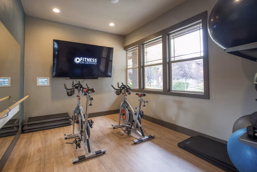 Well-equipped yoga/spin studio with modern bikes and mats at Whisper Sky Apartments offering luxurious fitness options