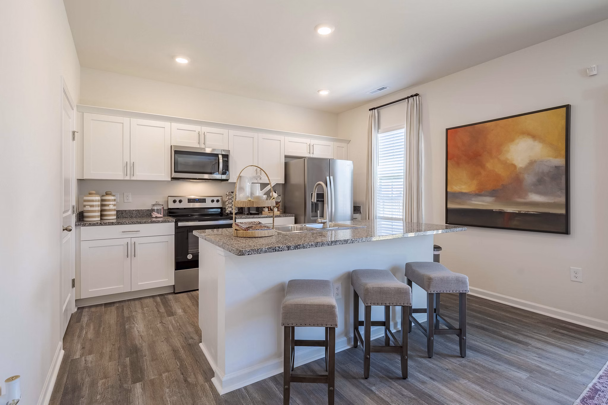 Modern kitchen with stainless steel appliances and granite countertops in Summerwell Harmony Apartments