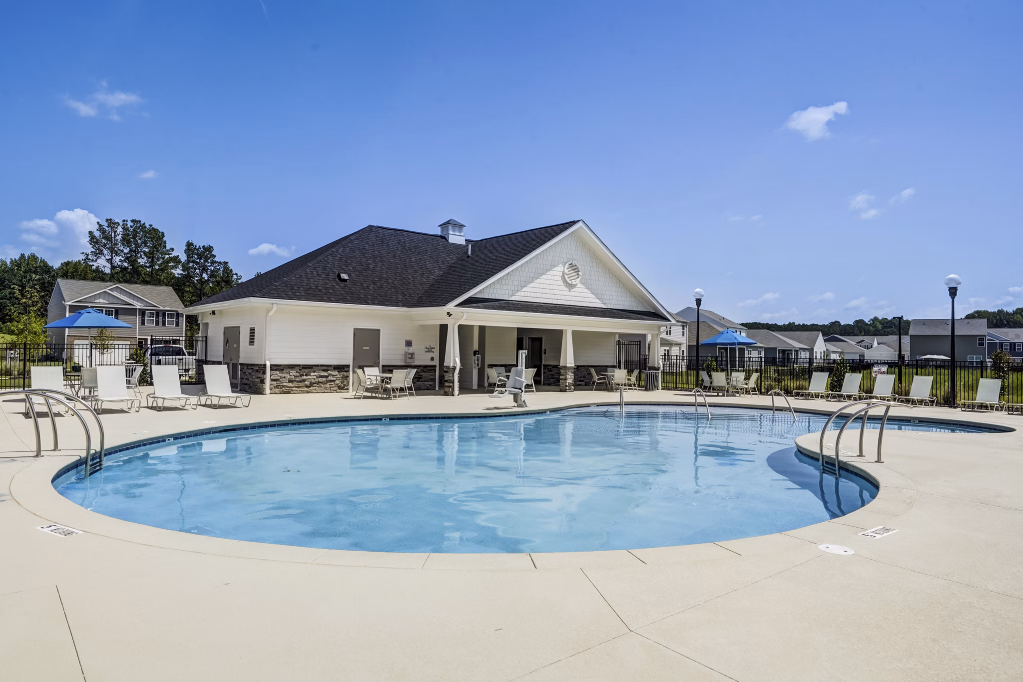 Outdoor swimming pool with lounge chairs at Summerwell Harmony luxury apartments
